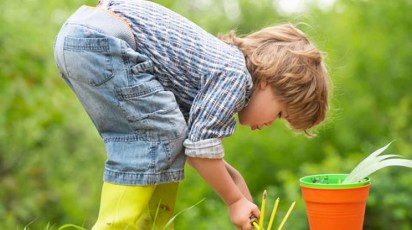 kleuter werkt in de tuin