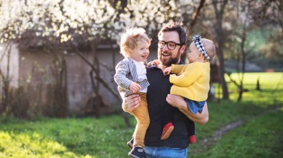 vader met peuter en baby op zijn arm