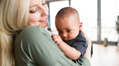 Jonge moeder met baby in haar armen