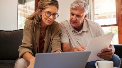Dame en heer kijken samen naar computer