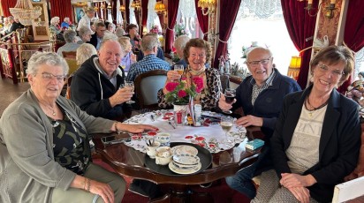 mensen zitten gezellig met elkaar aan tafel