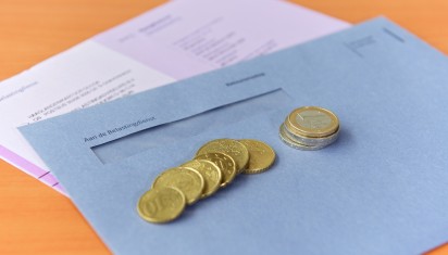 Blauwe belastingenvelop met muntgeld erop